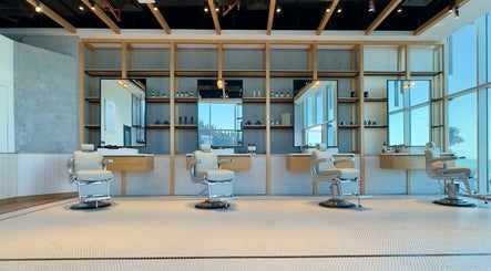 Interior of Akin Barber & Shop AbuDhabi By The Creek in Abu Dhabi, featuring modern barber chairs and sleek decor.