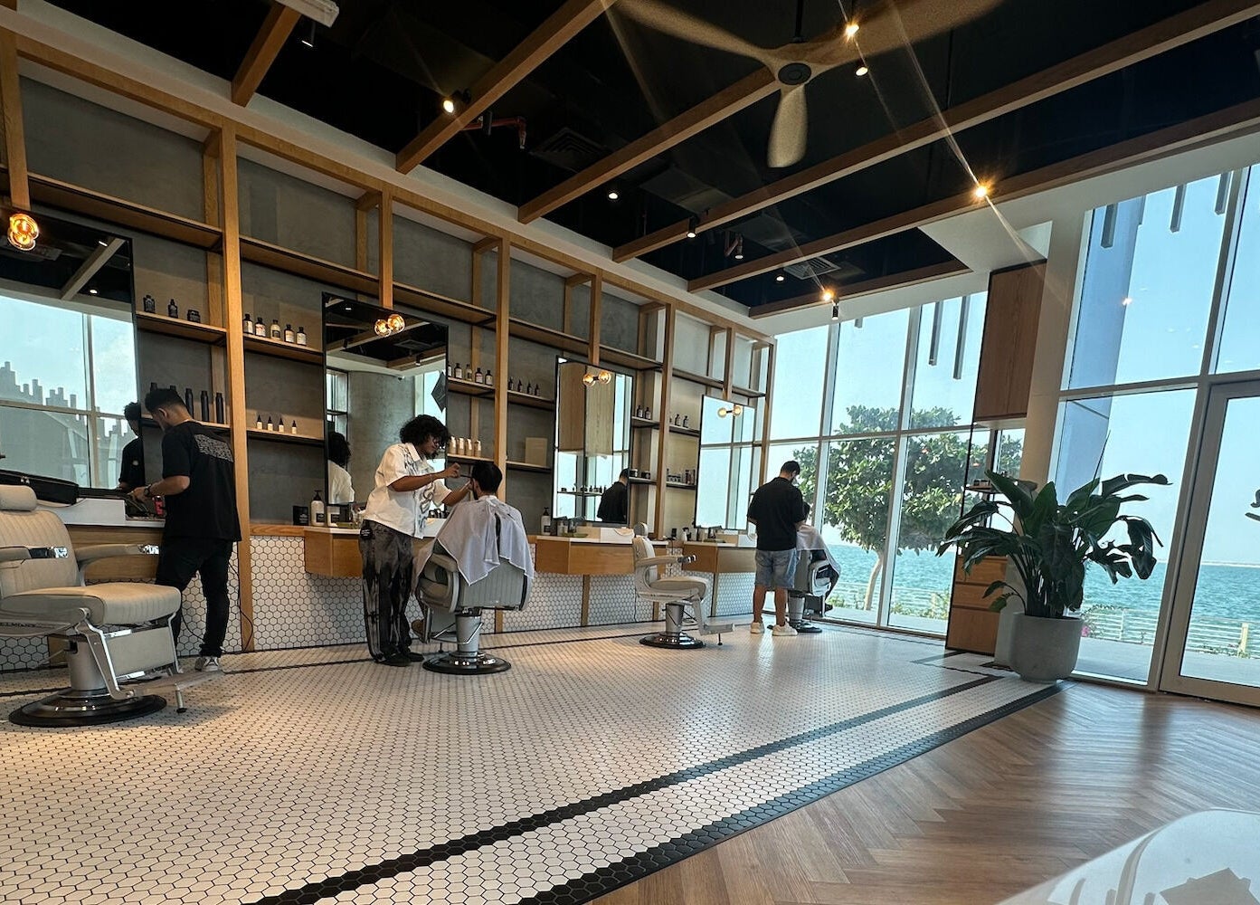 Modern interior of Akin Barber & Shop Abu Dhabi By The Creek, Abu Dhabi, AE with stylists at work.