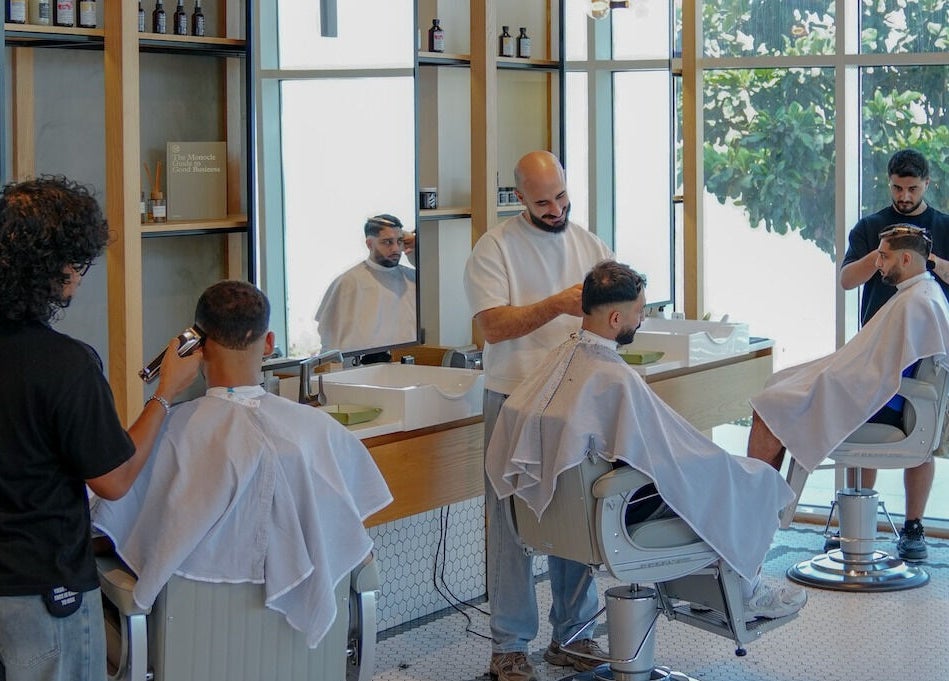 Stylish haircuts at Akin Barber & Shop AbuDhabi By The Creek, Abu Dhabi, AE with natural light and greenery.