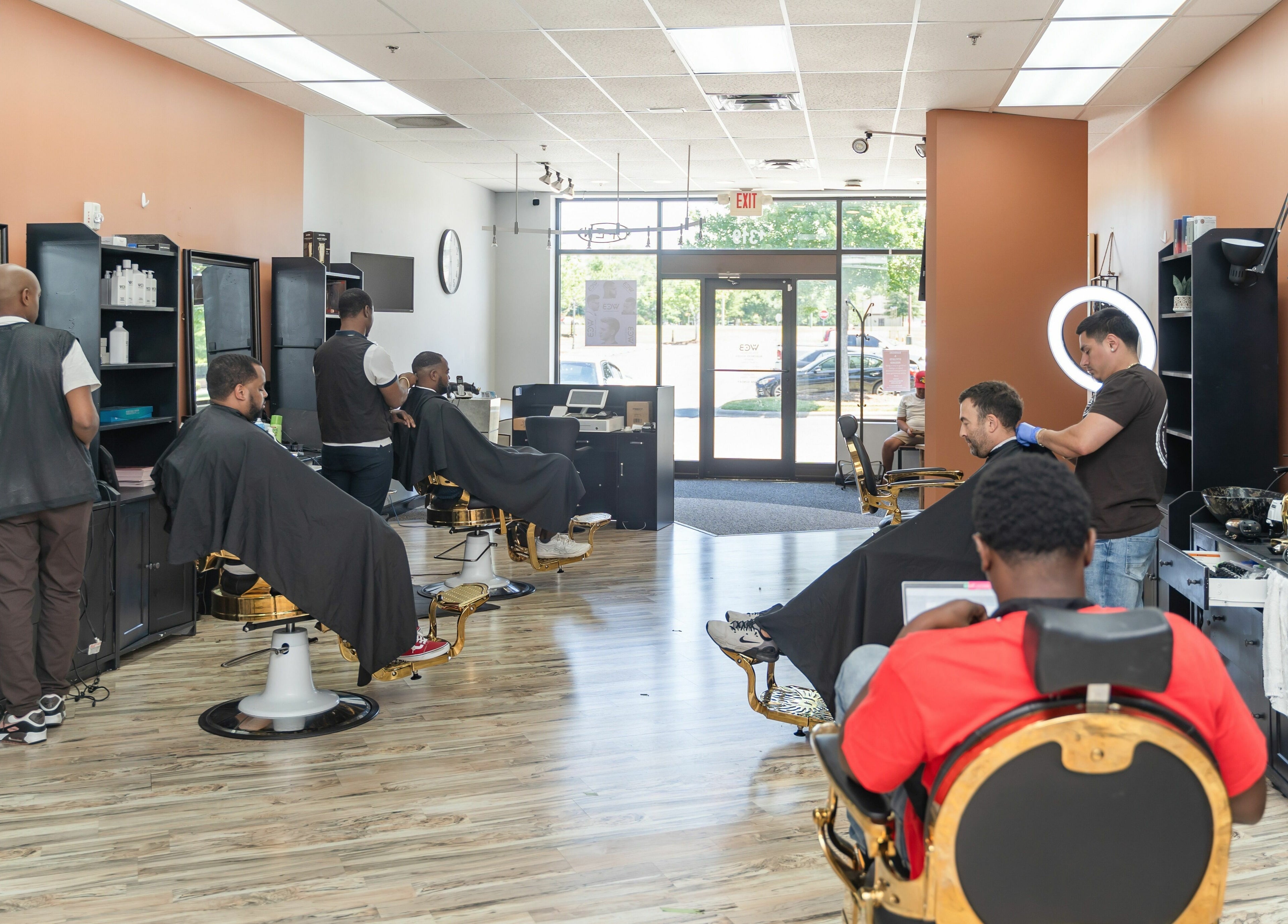 Modern interior of World Class Barbers - Matthews, North Carolina, US showcasing barbers and clients in action.