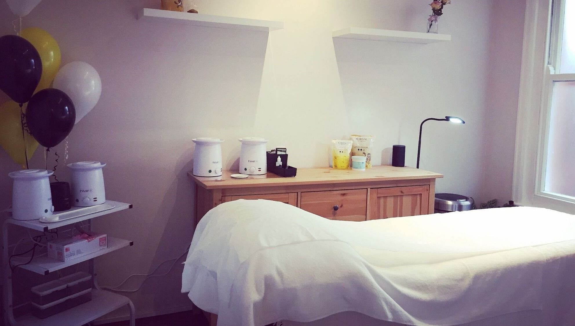 Elegant treatment room at The Wax Room, Paignton, England, GB with warm lighting and modern decor.