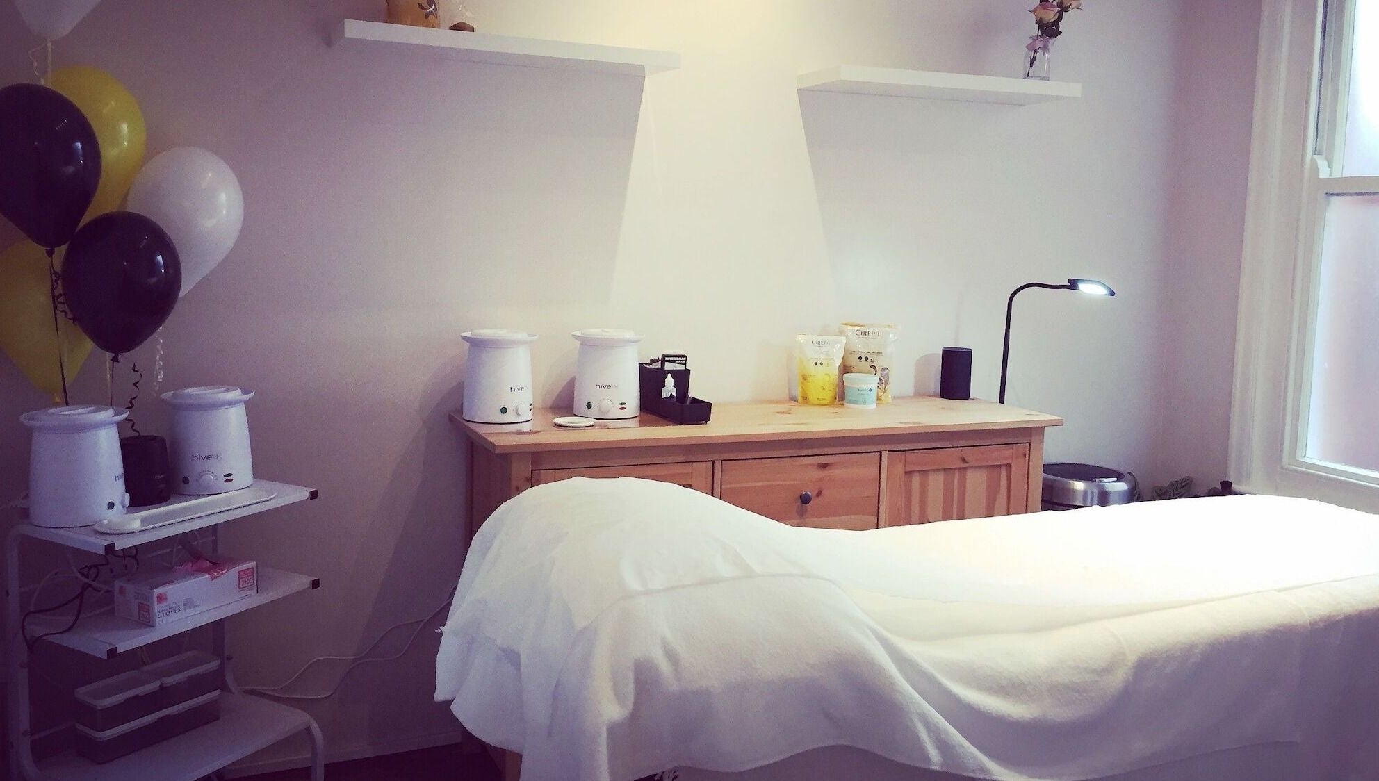 Elegant treatment room at The Wax Room, Paignton, England, GB with warm lighting and modern decor.