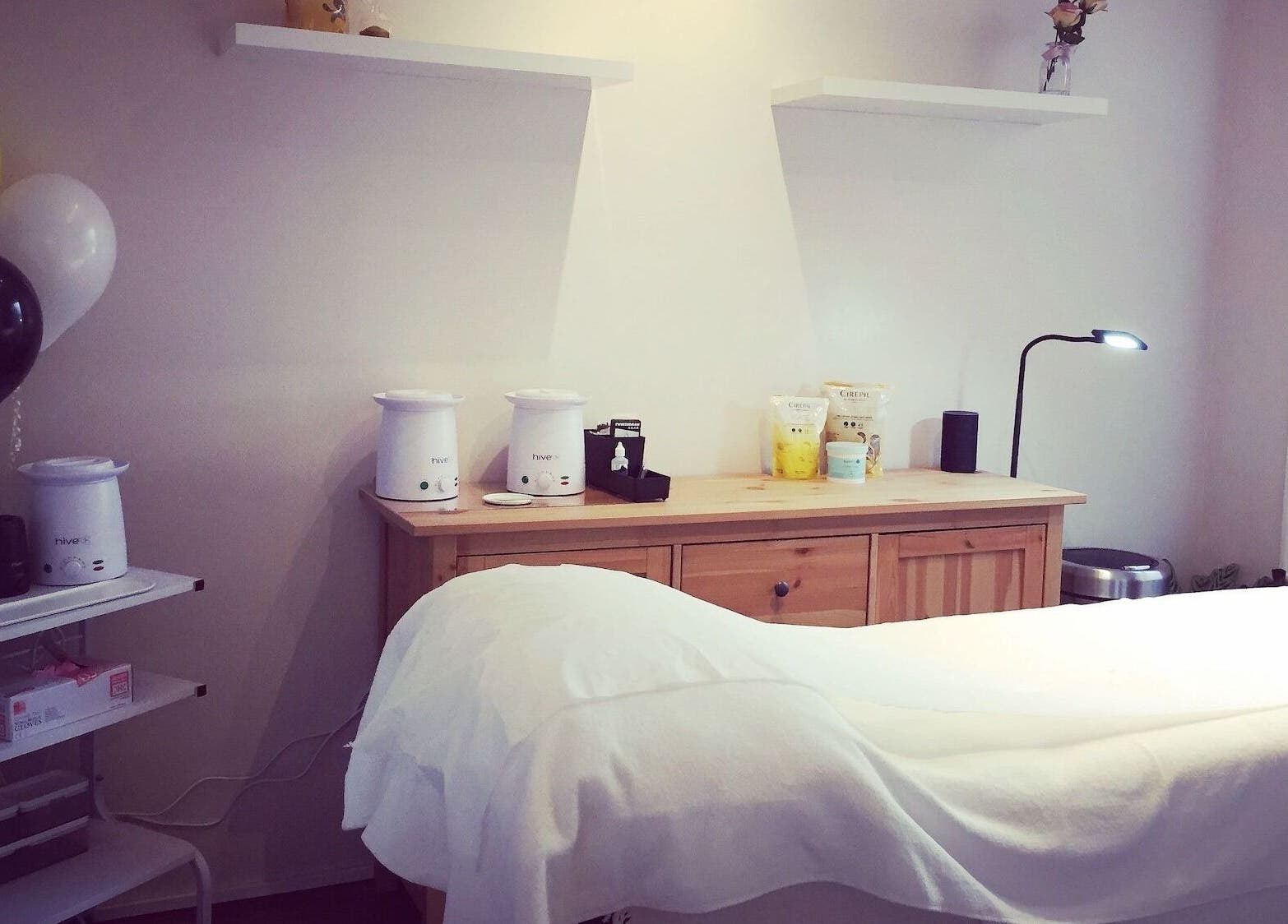 Elegant treatment room at The Wax Room, Paignton, England, GB with warm lighting and modern decor.