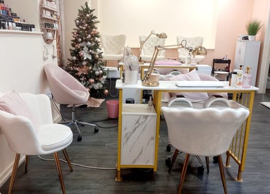 Chic interior of Myrto Zafeiropoulou salon in Birmingham, England, GB, with plush chairs and a festive tree.