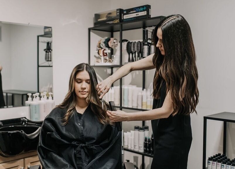 Stylist at Karen Giesbrecht Salon in Winkler, Manitoba, CA giving a client a chic haircut.