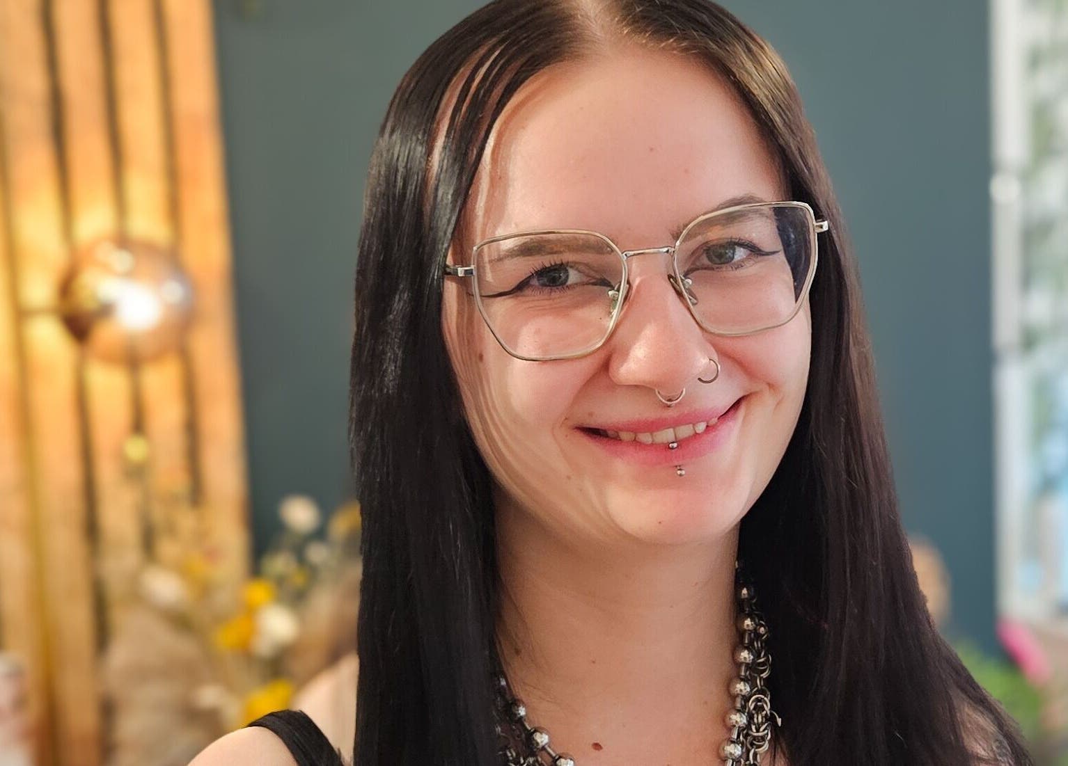 Smiling individual with long hair in Offbeat Beauty Collective, Sheffield, England, GB.