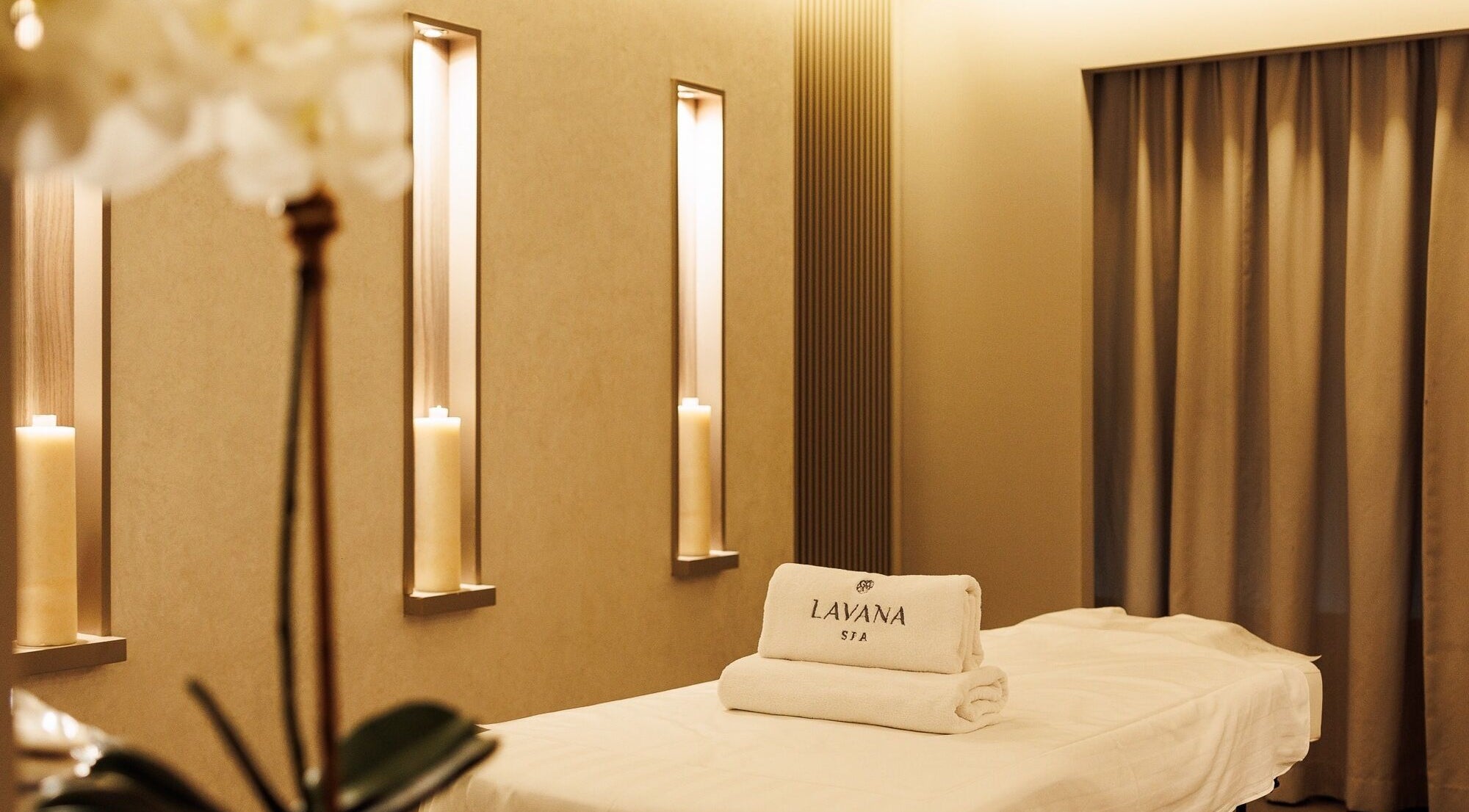 Serene spa room at Lavana Spa - DIFC, Dubai, Dubai, AE with soft lighting and plush white towels.