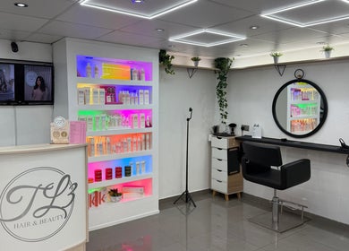 Modern interior of TL3 Hair and Beauty in London Colney, England, GB featuring vibrant product display and styling chair.