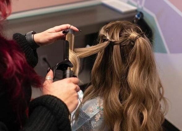 Stylist curling hair at The Grey Rose Salon, Dallas, Pennsylvania, US. Elegant salon experience with expert care.