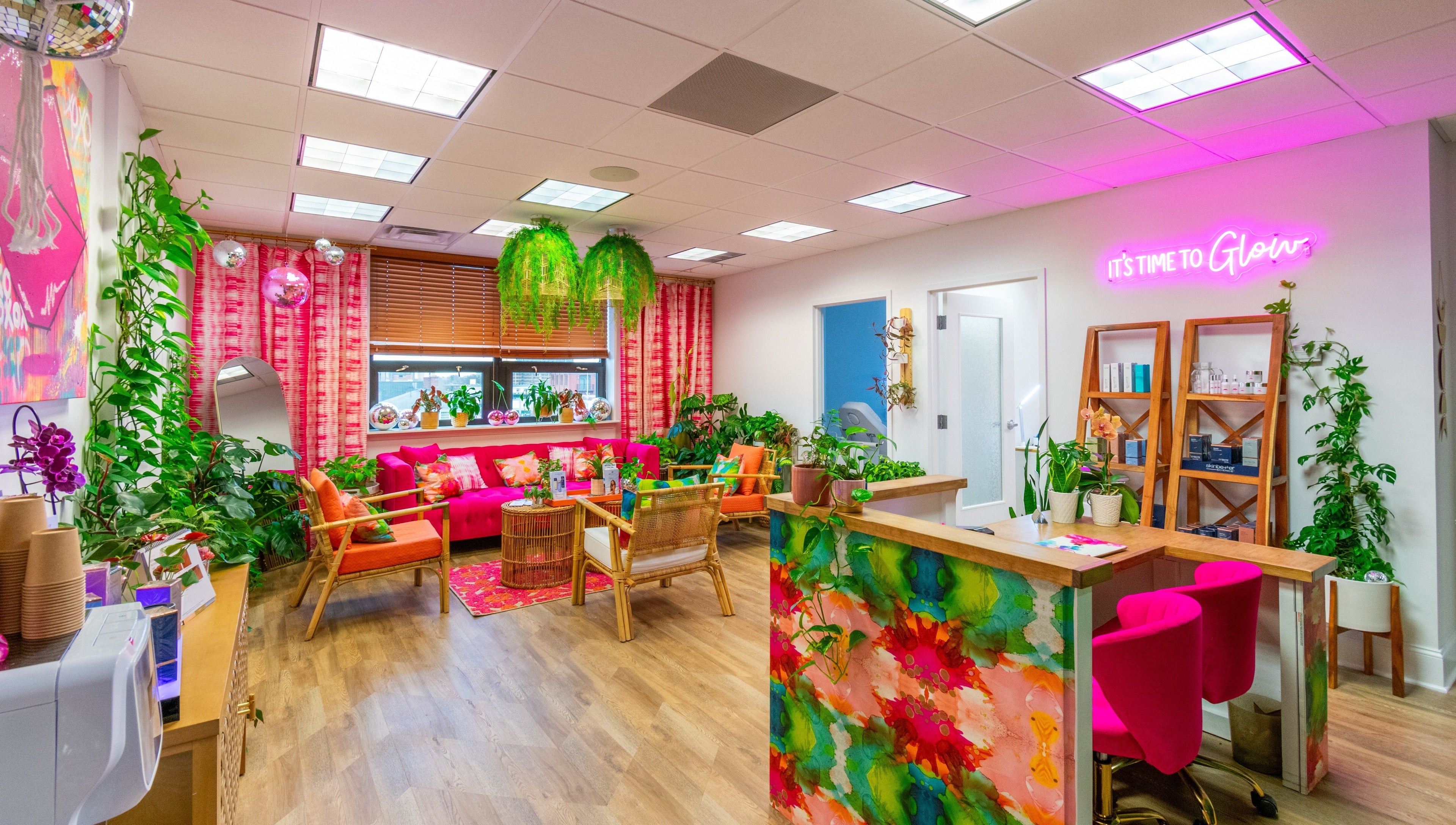The Lip Loft in Medford, Massachusetts offers a vibrant, colorful lounge area with plants and neon lights.