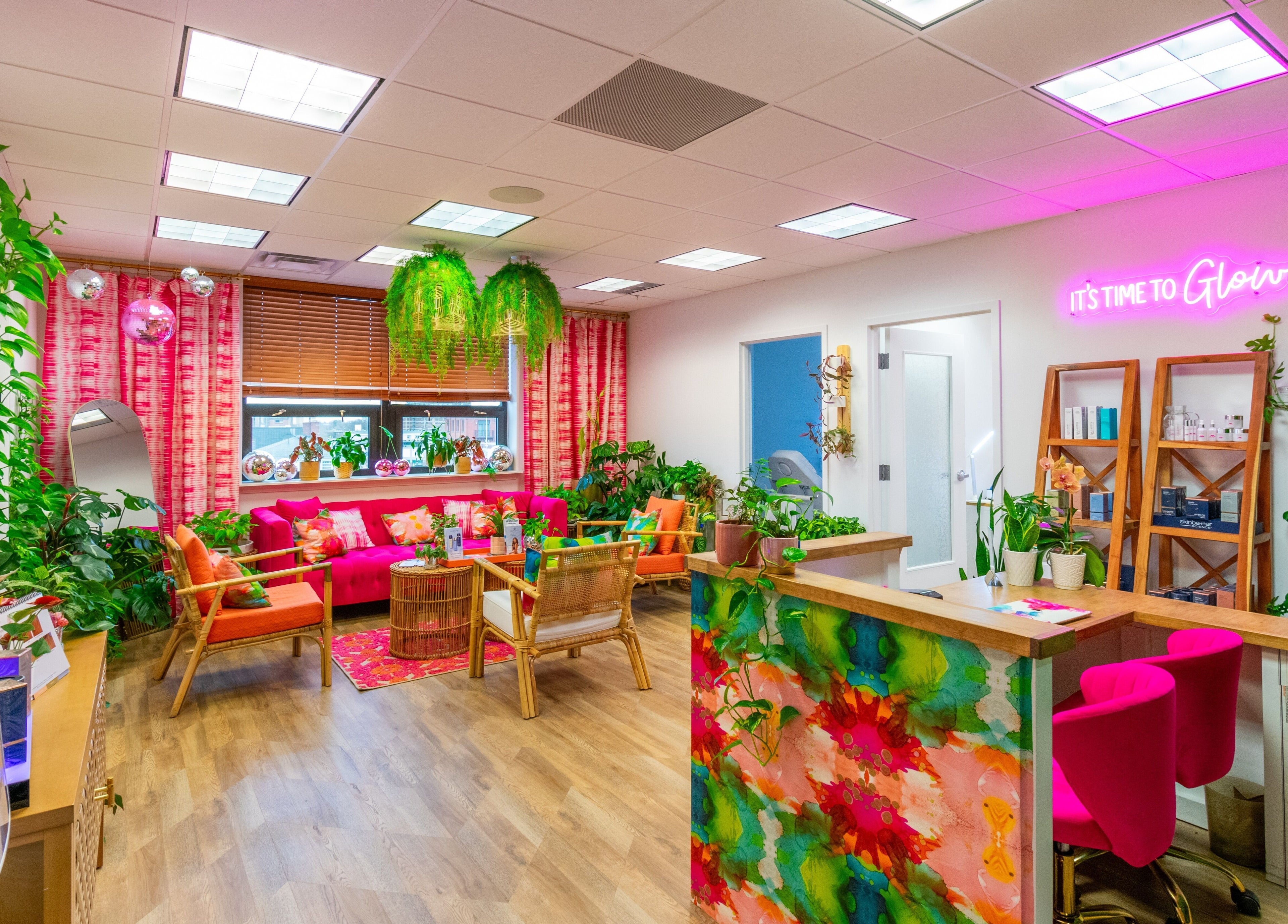 The Lip Loft in Medford, Massachusetts offers a vibrant, colorful lounge area with plants and neon lights.