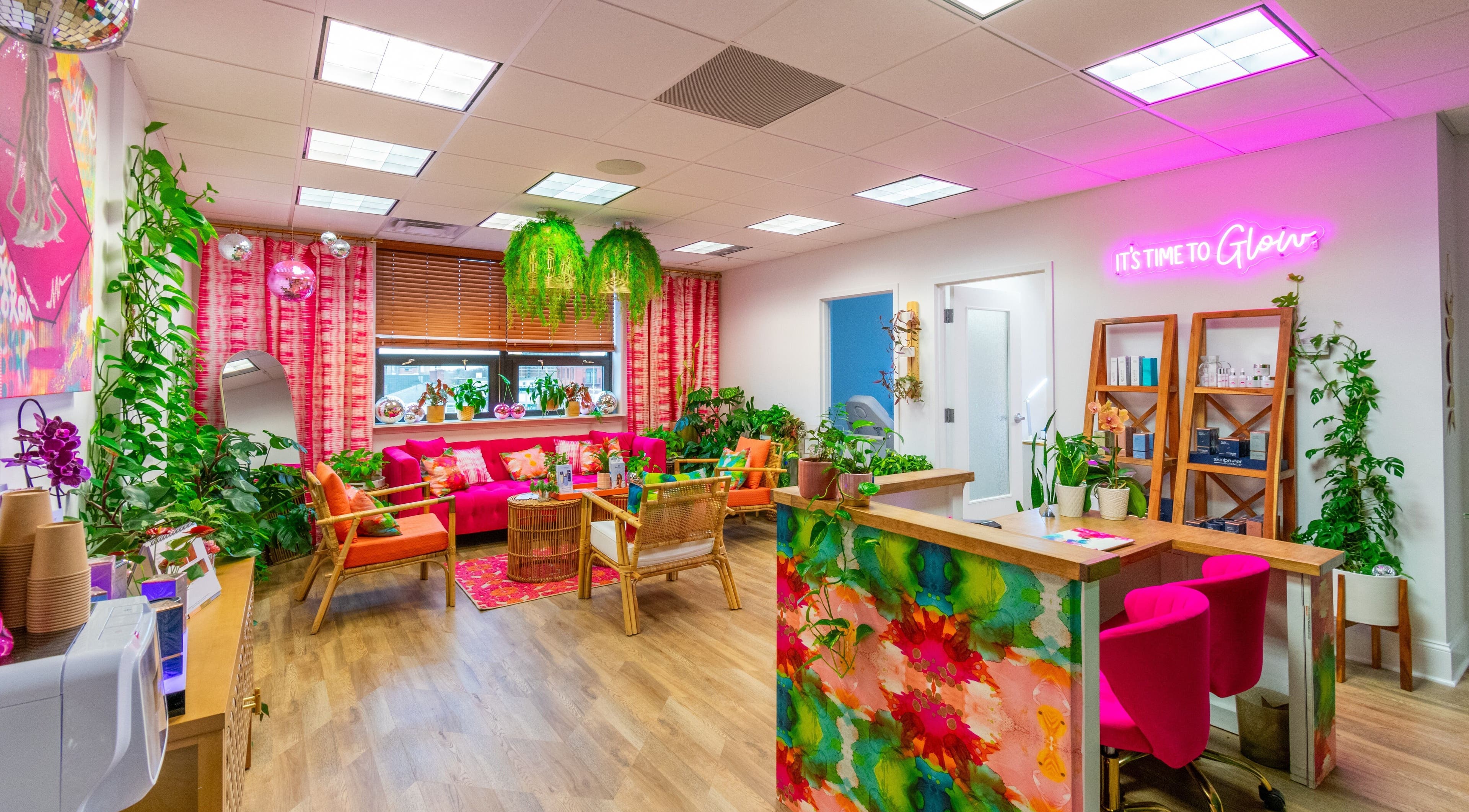 The Lip Loft in Medford, Massachusetts offers a vibrant, colorful lounge area with plants and neon lights.