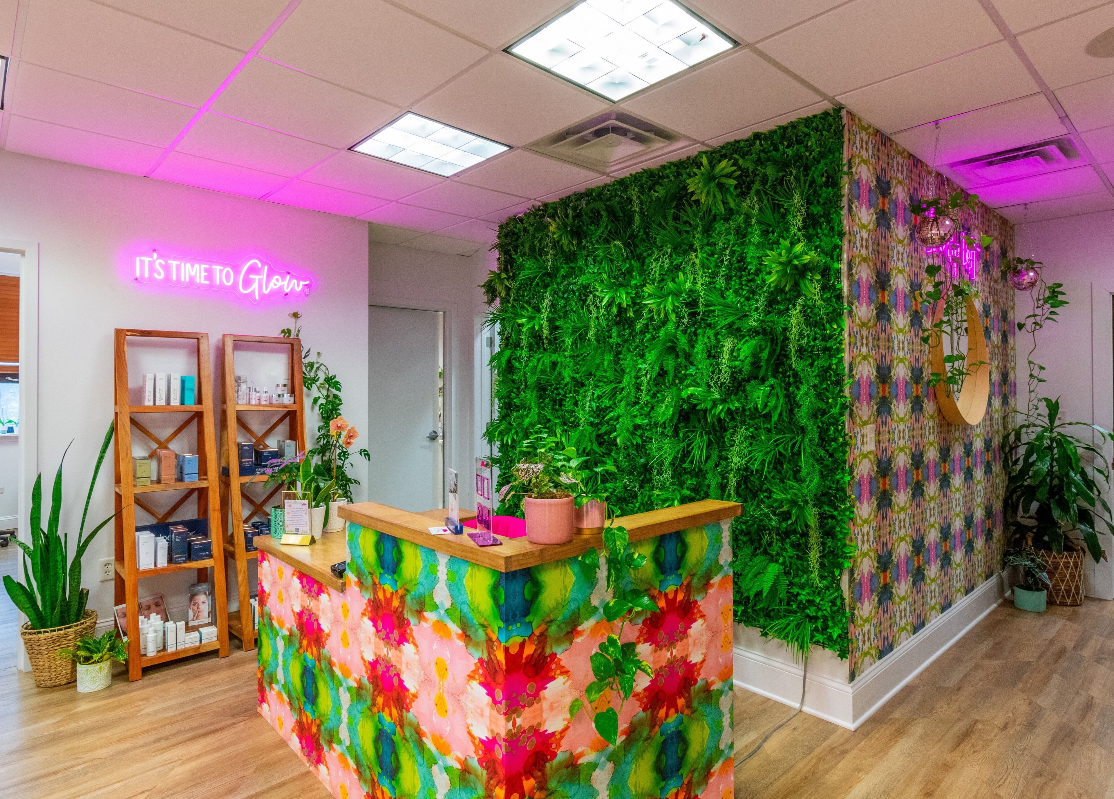 Reception area at The Lip Loft, Medford, Massachusetts, US with lush greenery and bright decor.