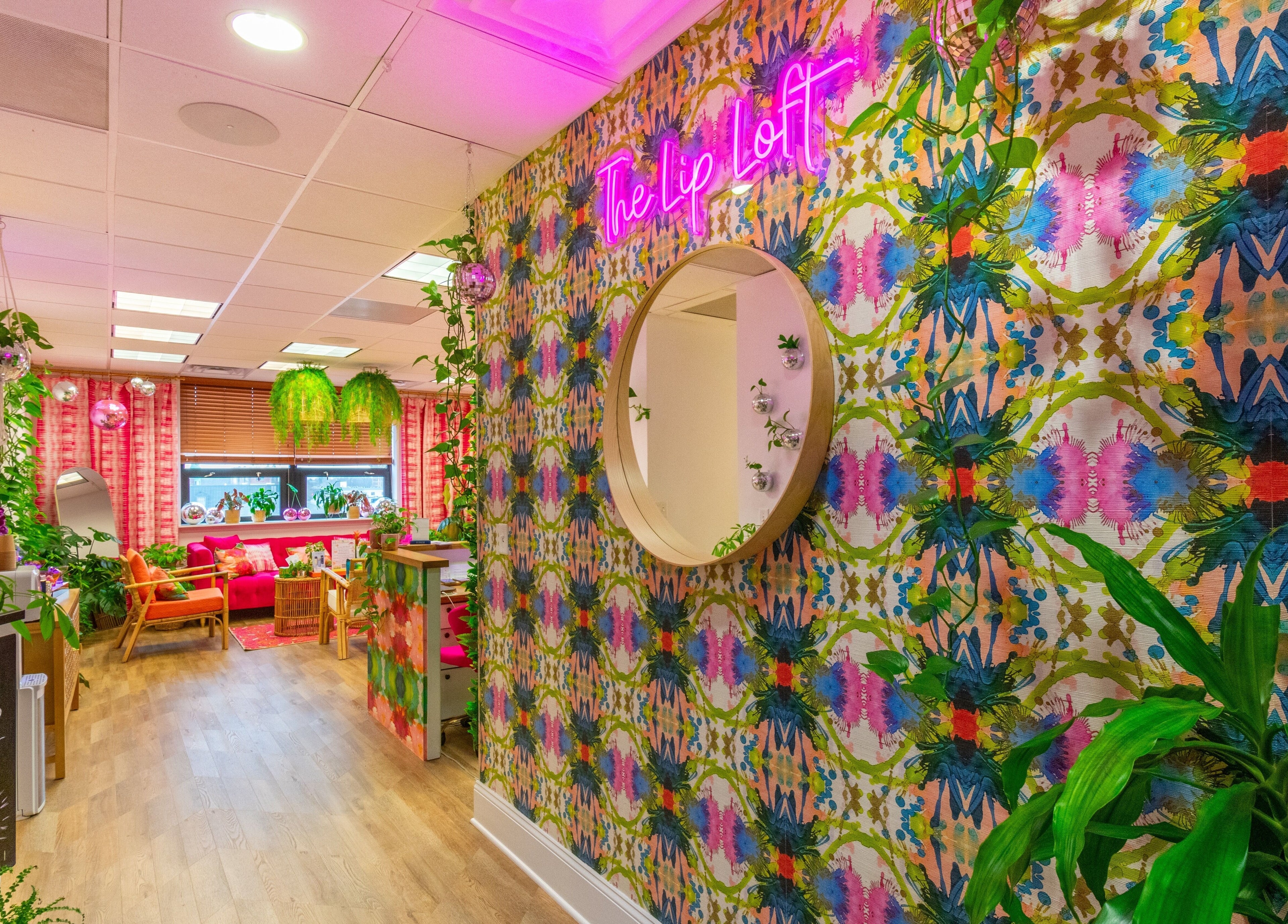 Colorful interior of The Lip Loft in Medford, Massachusetts, US, featuring bold patterns and lush greenery.