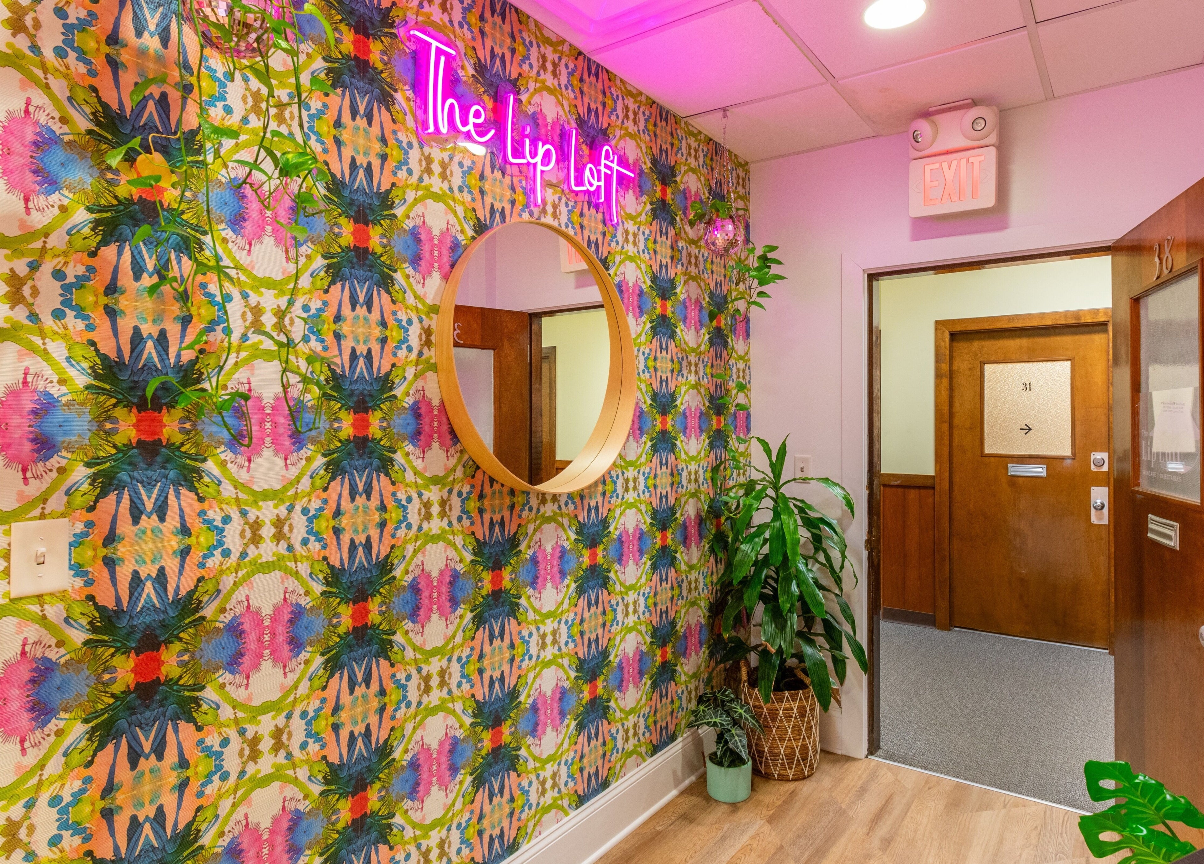 Vibrant entrance of The Lip Loft in Medford, Massachusetts, US featuring a colorful wall and plants.
