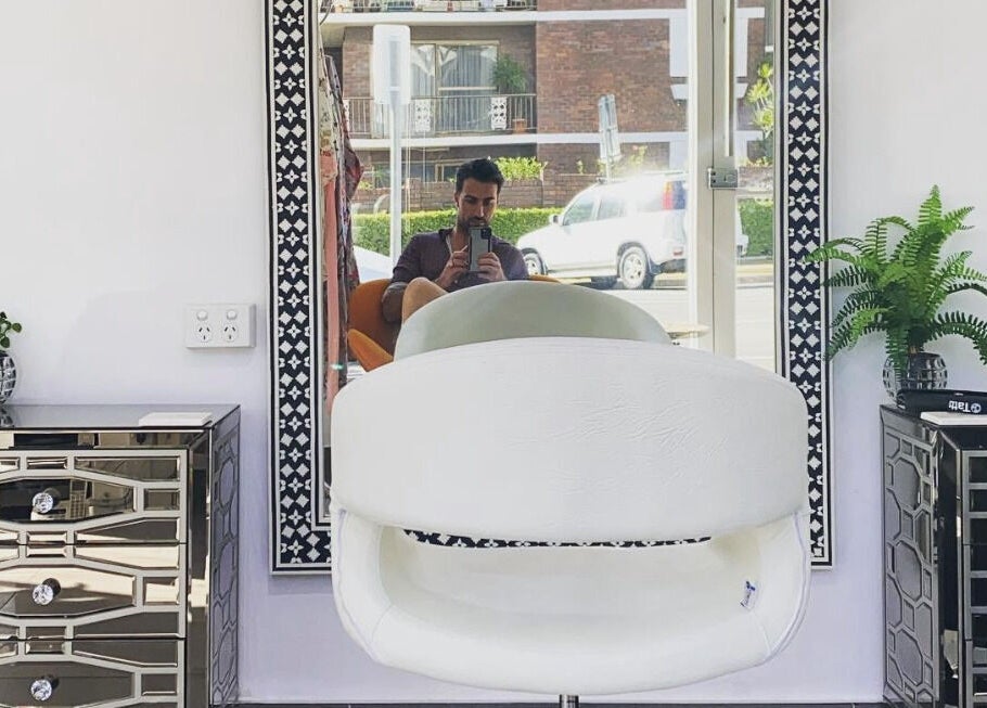 Modern salon chair at Jacob Zinsli Salon, Surfers Paradise, Queensland, AU with sleek decor and a large mirror.