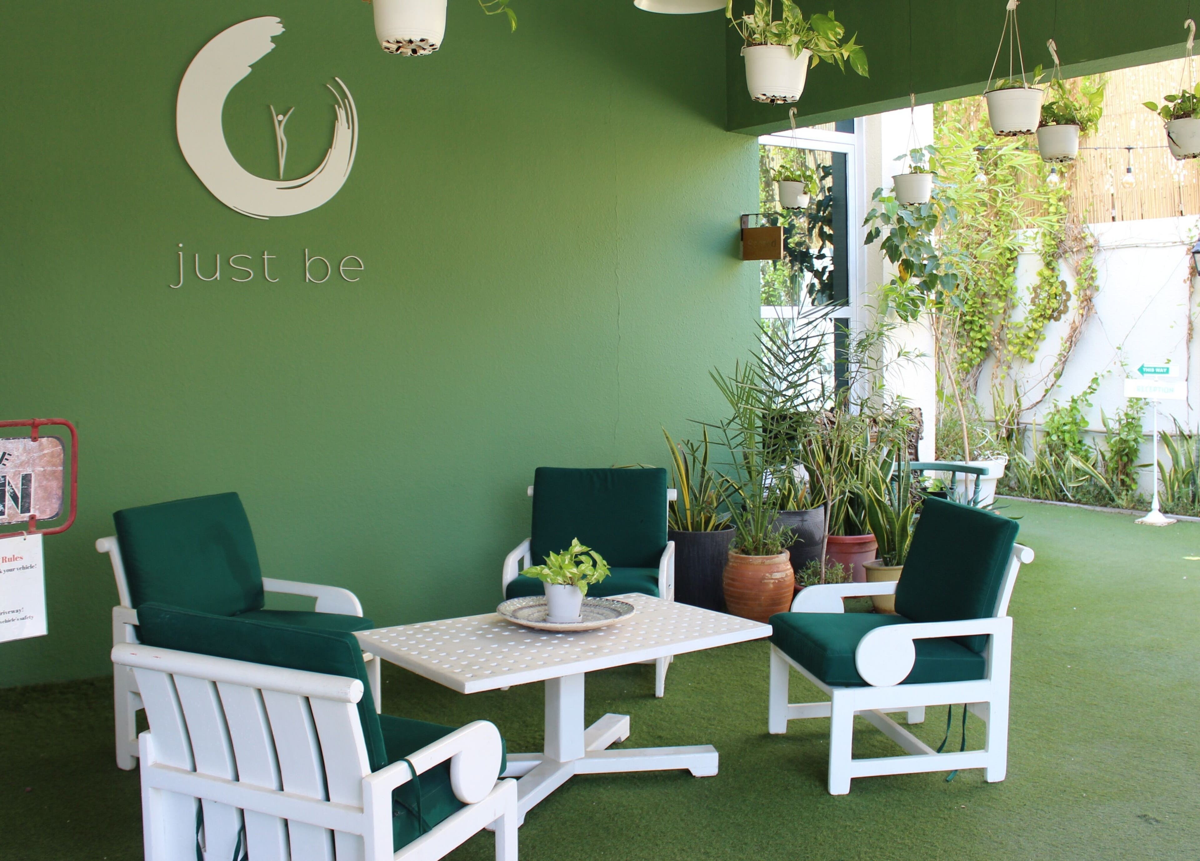 Cozy green lounge at I Am More, Dubai, Dubai, AE, featuring elegant seating and lush plants.