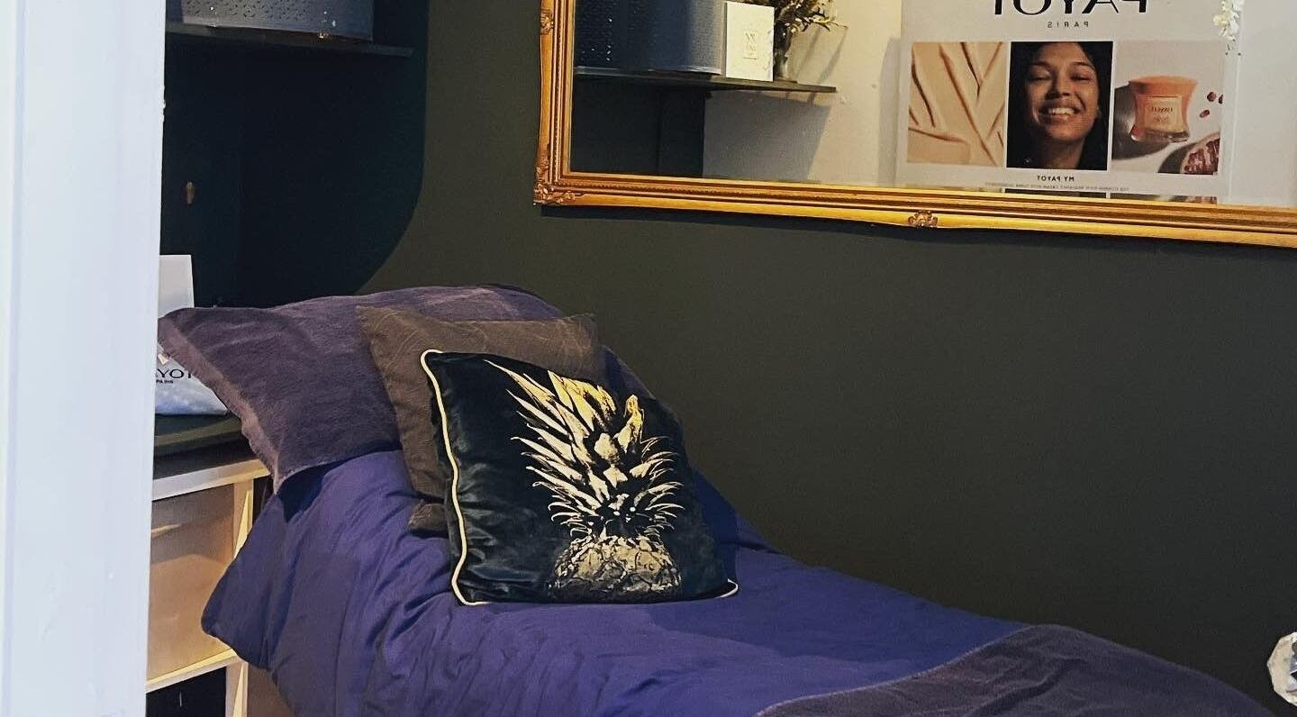 Cozy treatment room at Queens Parlour, Macclesfield, England, GB, featuring plush bedding and elegant decor.