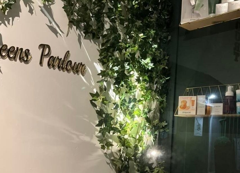 Queens Parlour entrance with lush greenery in Macclesfield, England, GB. Elegantly decorated walls and shelves.