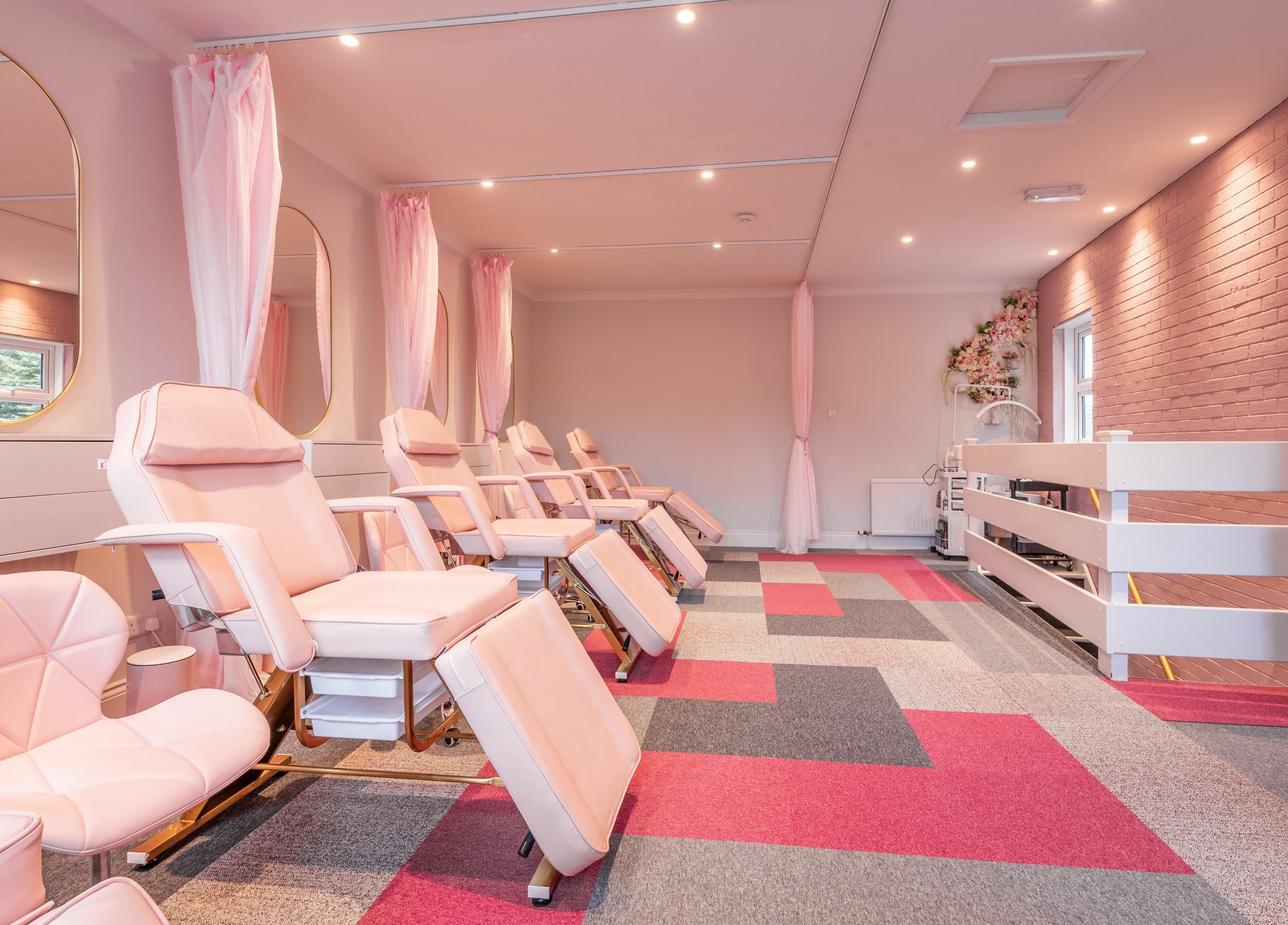 Spacious beauty treatment room at Pink. Academy, Worsley, England, GB with elegant pink chairs and bright decor.