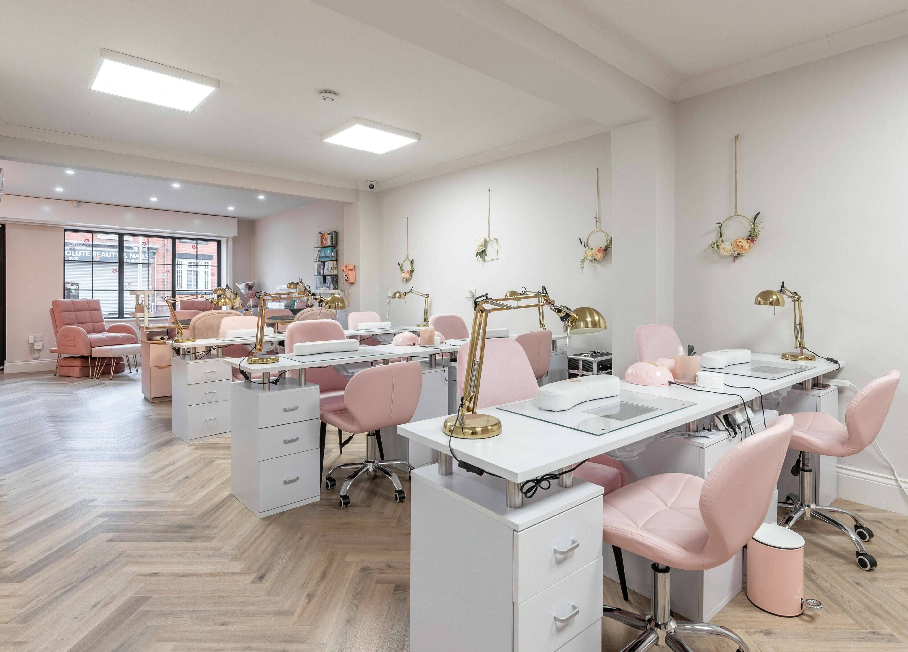 Elegant interior of Pink. Academy, Worsley, England, GB, featuring stylish pink chairs and modern nail stations.