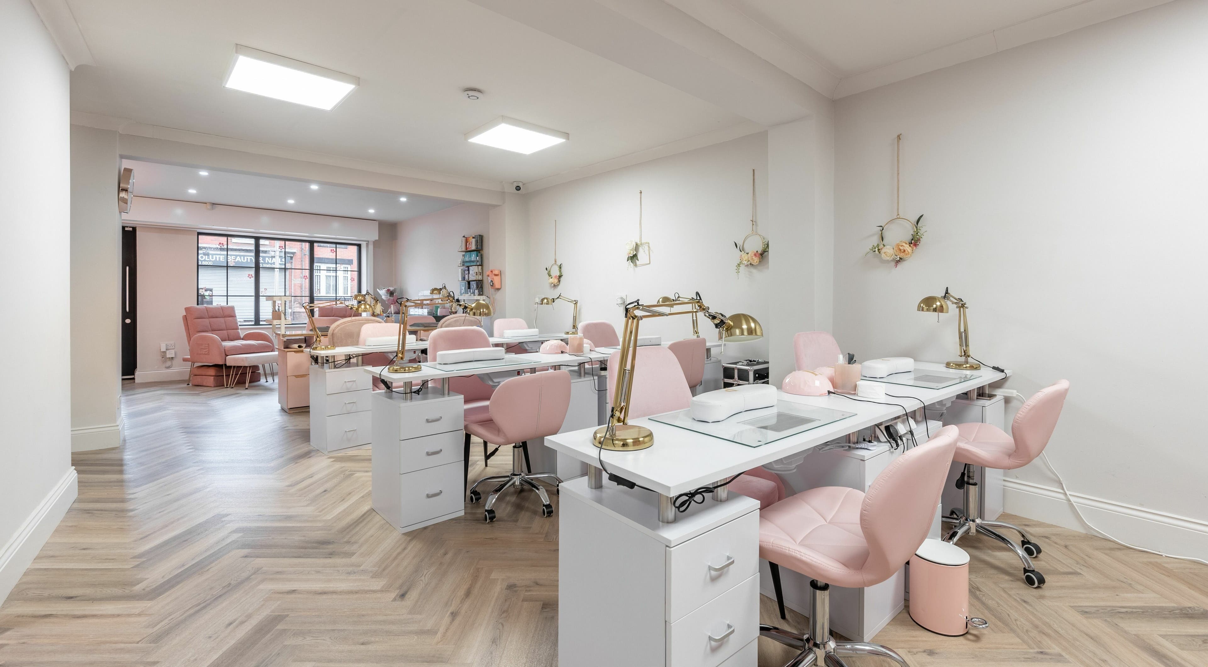 Elegant interior of Pink. Academy, Worsley, England, GB, featuring stylish pink chairs and modern nail stations.