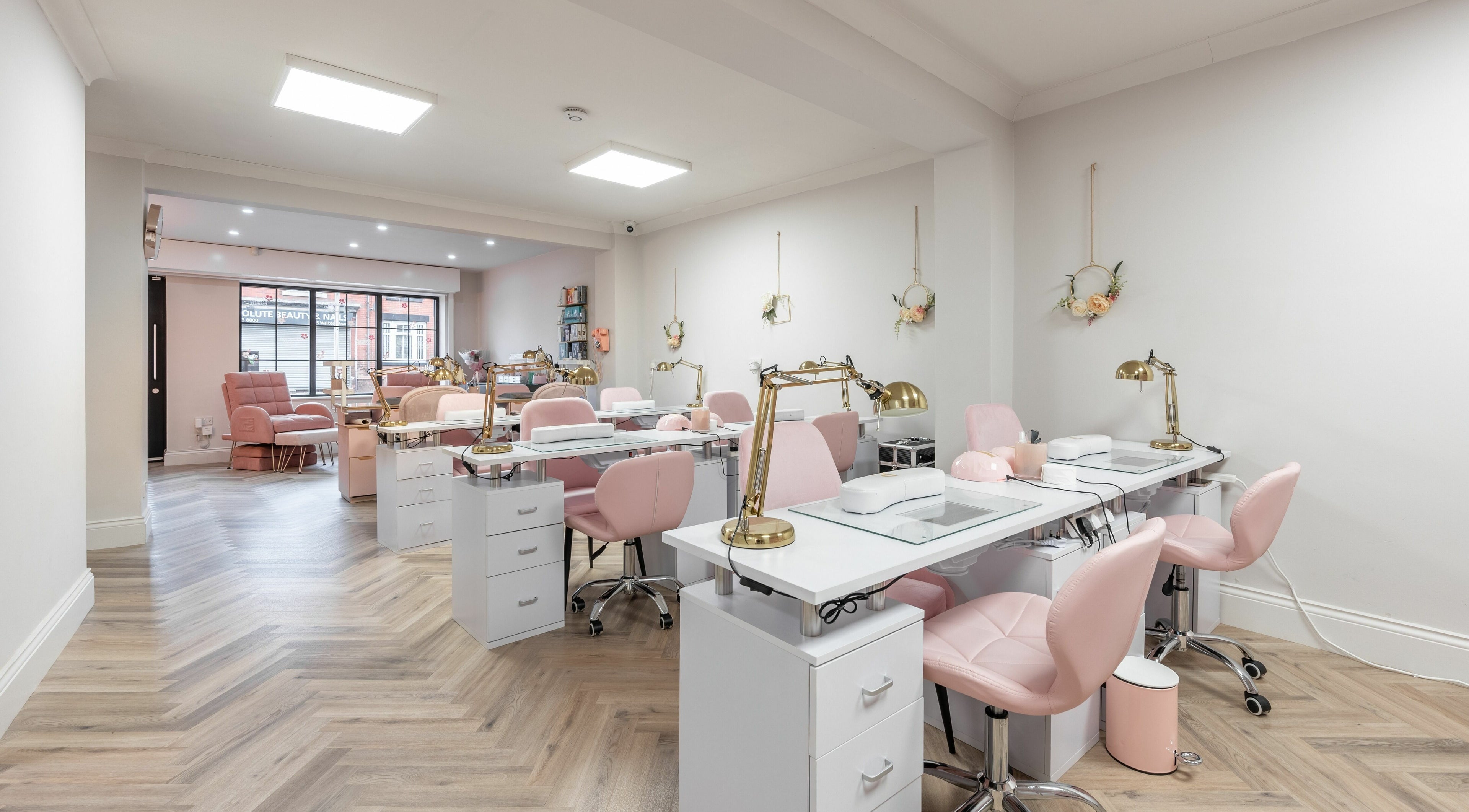Elegant interior of Pink. Academy, Worsley, England, GB, featuring stylish pink chairs and modern nail stations.