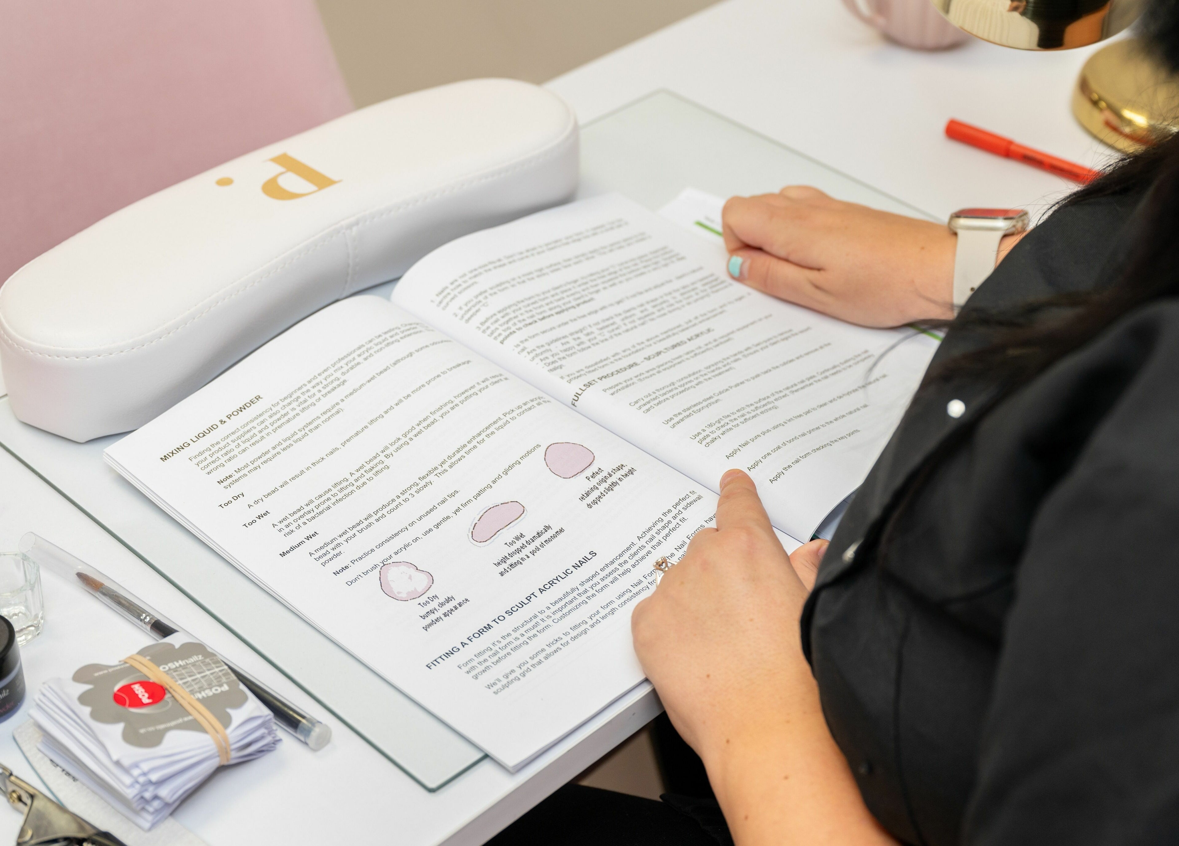 Student engaged in nail art learning at Pink. Academy, Worsley, England, GB with tools and manual.