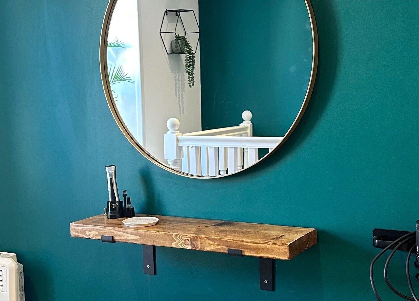 Elegant salon setup with a round mirror and wooden shelf at Fringe, Bolsover, England, GB.