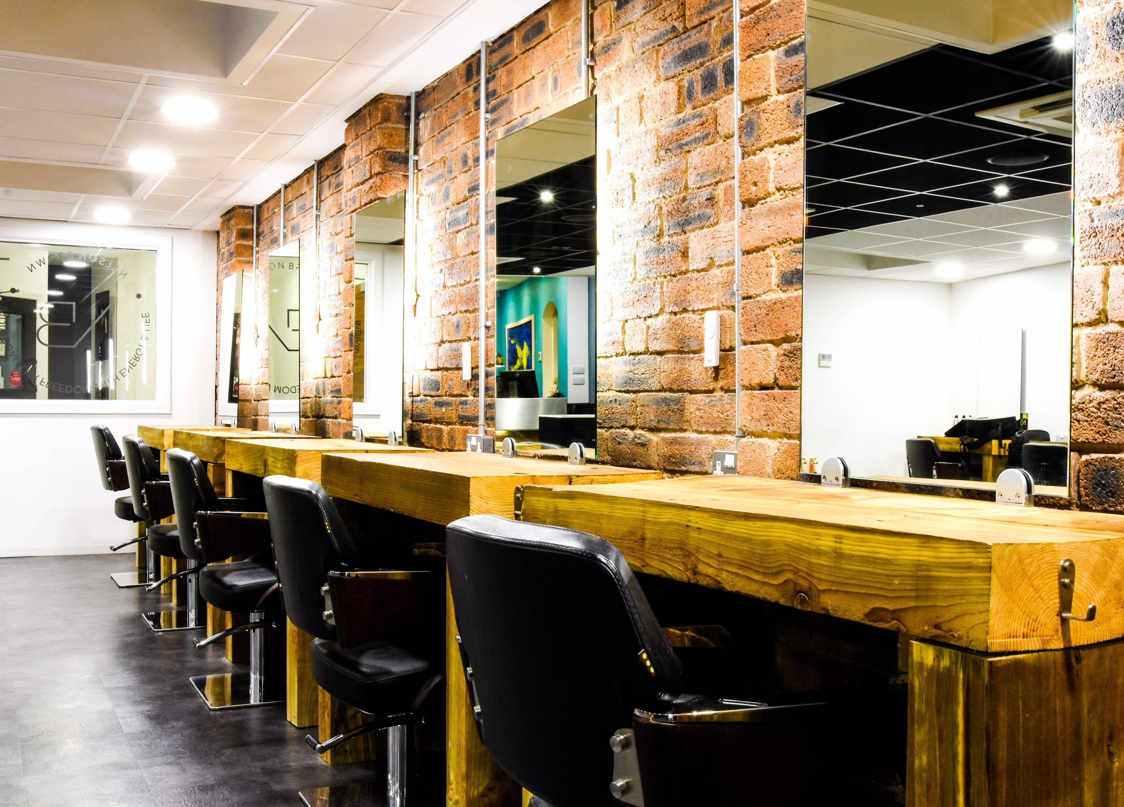 Stylish salon interior with rustic wooden workstations at Nelson Brown, Dumfries, Scotland, GB.