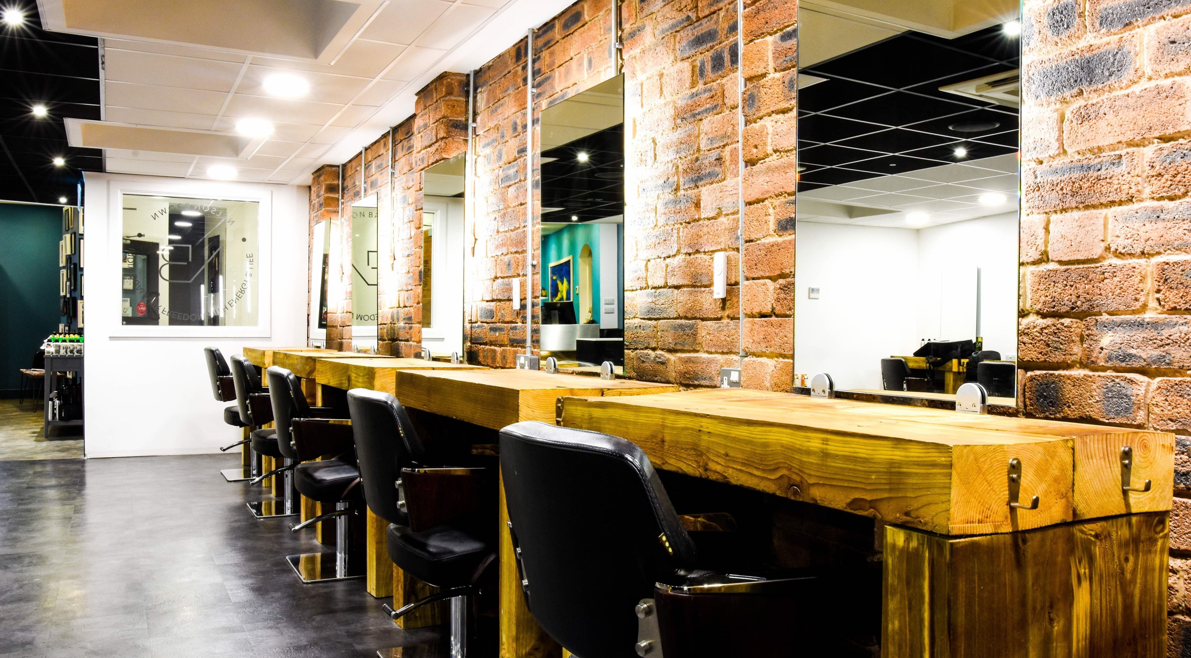Stylish salon interior with rustic wooden workstations at Nelson Brown, Dumfries, Scotland, GB.