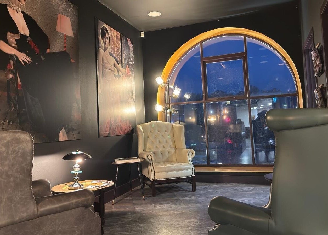 Modern lounge area at Nelson Brown, Dumfries, Scotland, GB, with luxurious chairs and large arched window.