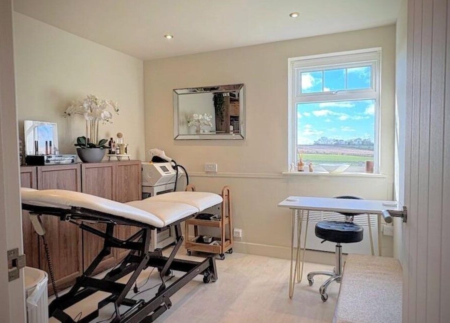 Bright treatment room at Proper Beauty Chicheley, Newport Pagnell, England, with a view of the countryside.
