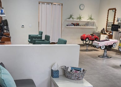 Interior view of Sage Kids Family Salon & Retail Boutique, West Linn, Oregon, US, featuring colorful car-shaped chairs.
