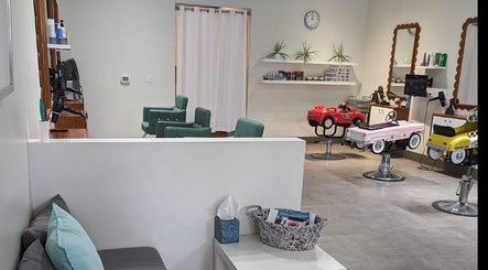 Interior view of Sage Kids Family Salon & Retail Boutique, West Linn, Oregon, US, featuring colorful car-shaped chairs.