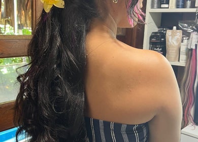 Stylish curled hair adorned with a yellow flower at CG Bella Extensions, St Thelmo by Abrazos hotel, San Pedro, BZ.