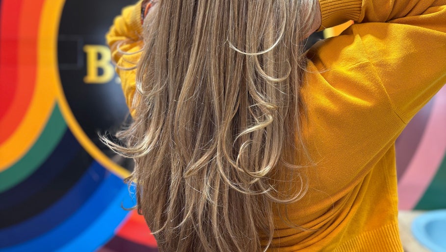 Elegant golden hair at Yo Barbra in Bacchus Marsh, Victoria, AU with vibrant rainbow backdrop.
