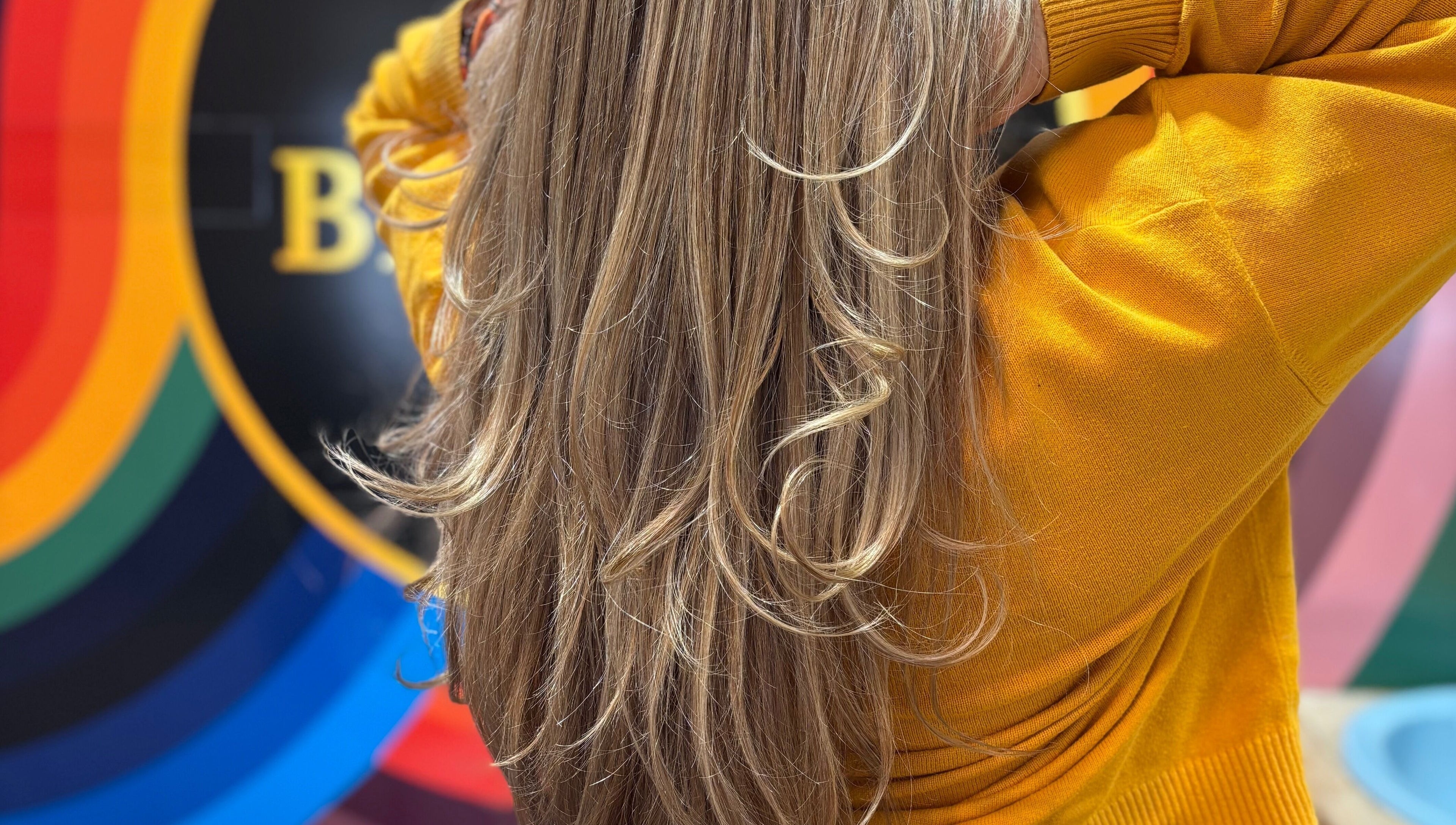 Elegant golden hair at Yo Barbra in Bacchus Marsh, Victoria, AU with vibrant rainbow backdrop.