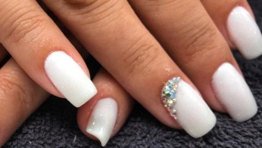 Elegant white nails with rhinestones at Nail Luxe, Davie, Florida, US showcasing stylish manicure.