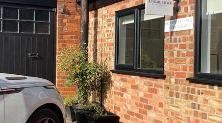 Entrance of Abigail Grace Beauty in Rugby, England, GB with a parked car and brick facade.