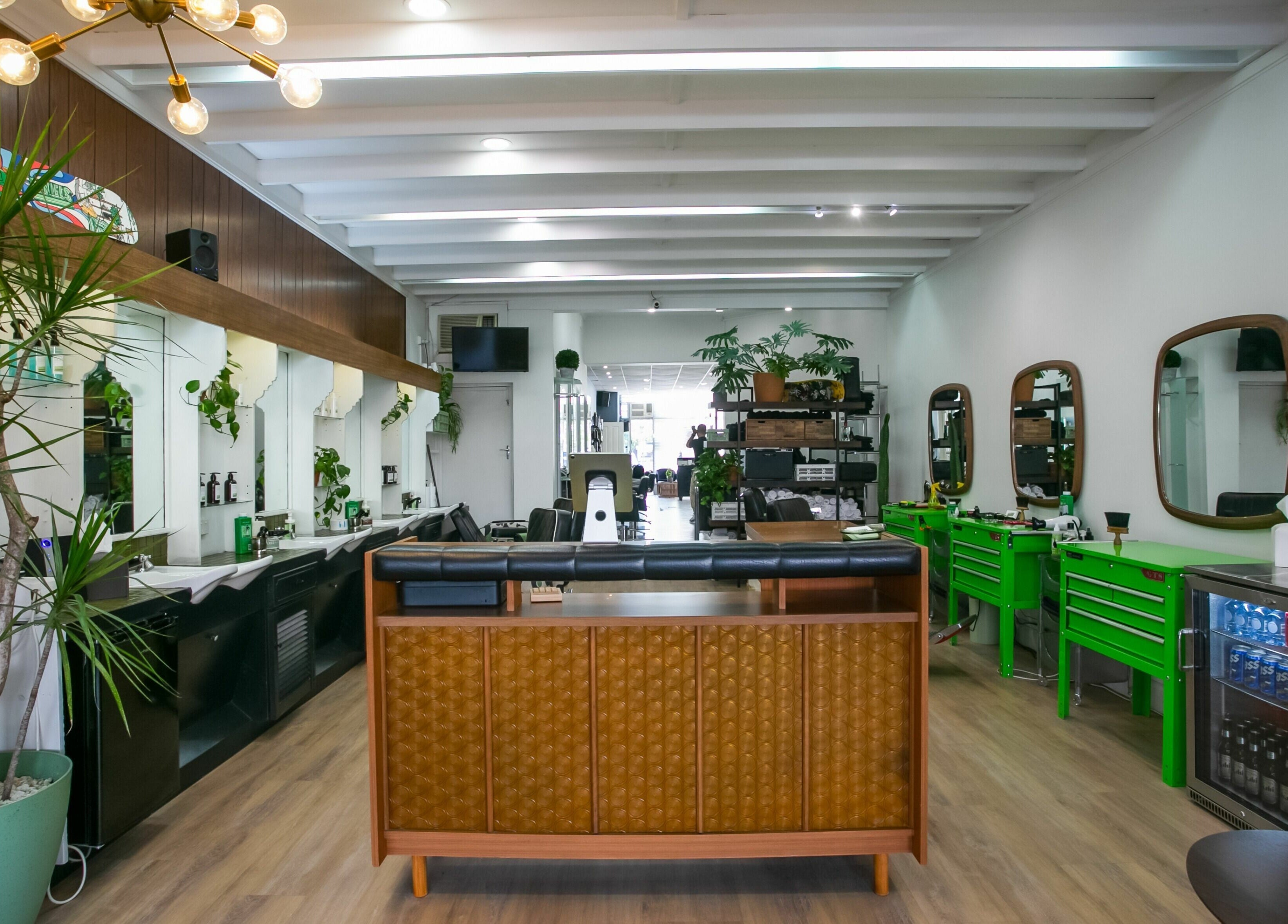 Interior of Daniel’s Barbershop in Melbourne, Victoria, AU, showcasing modern design and vibrant green stations.