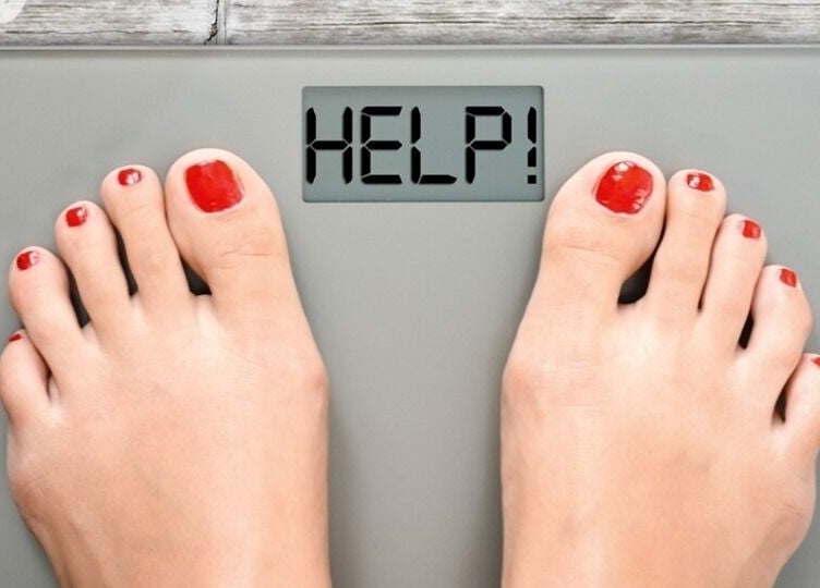 Feet on a scale reading 'HELP!' at Healthy Living Colorado, Aurora, Colorado, US.