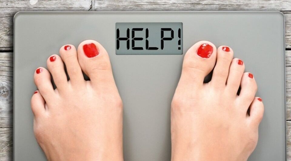 Feet on a scale reading 'HELP!' at Healthy Living Colorado, Aurora, Colorado, US.