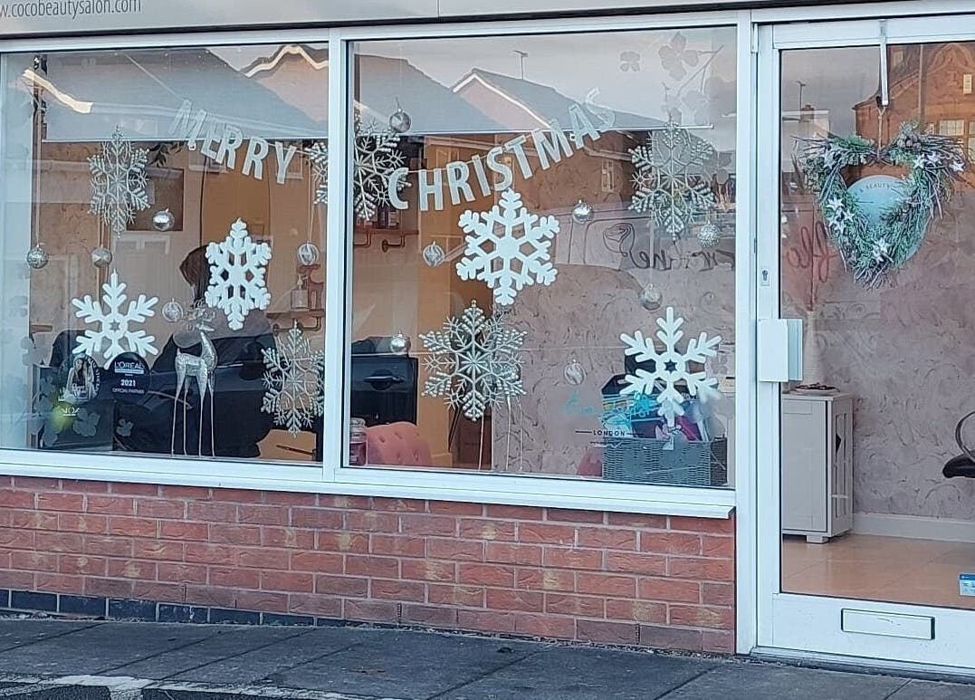 Coco Beauty's festive window display in Belper, England, GB with snowflakes and Christmas decor.