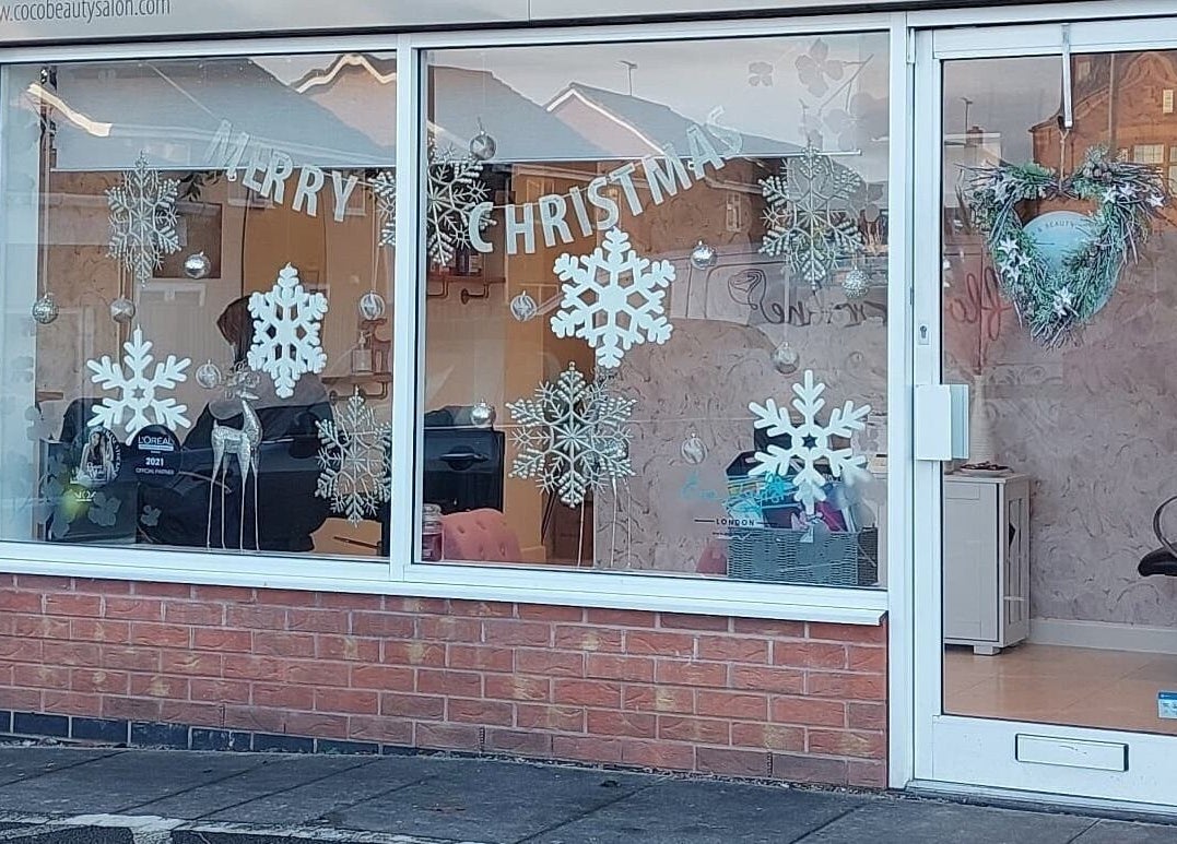 Coco Beauty's festive window display in Belper, England, GB with snowflakes and Christmas decor.