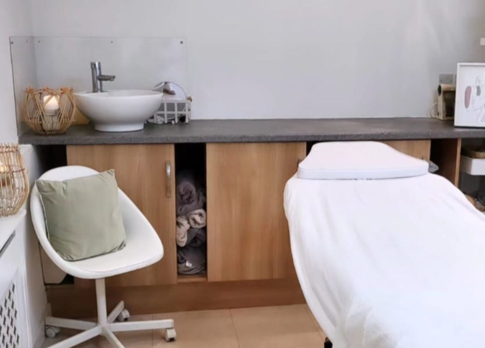 Tranquil treatment room at Coco Beauty in Belper, England, GB with white chair, massage table, and soft lighting.