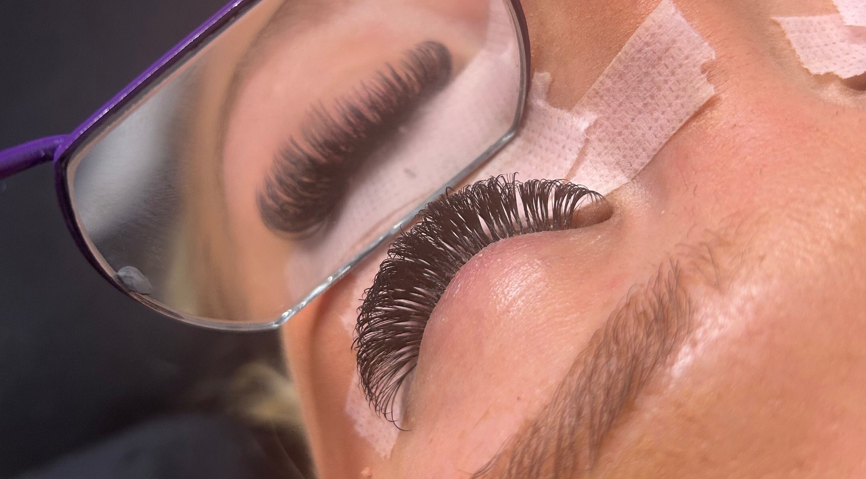 Close-up of eyelash extensions at LylaLash, Matson, England, GB, mirrored in stylist's glasses.