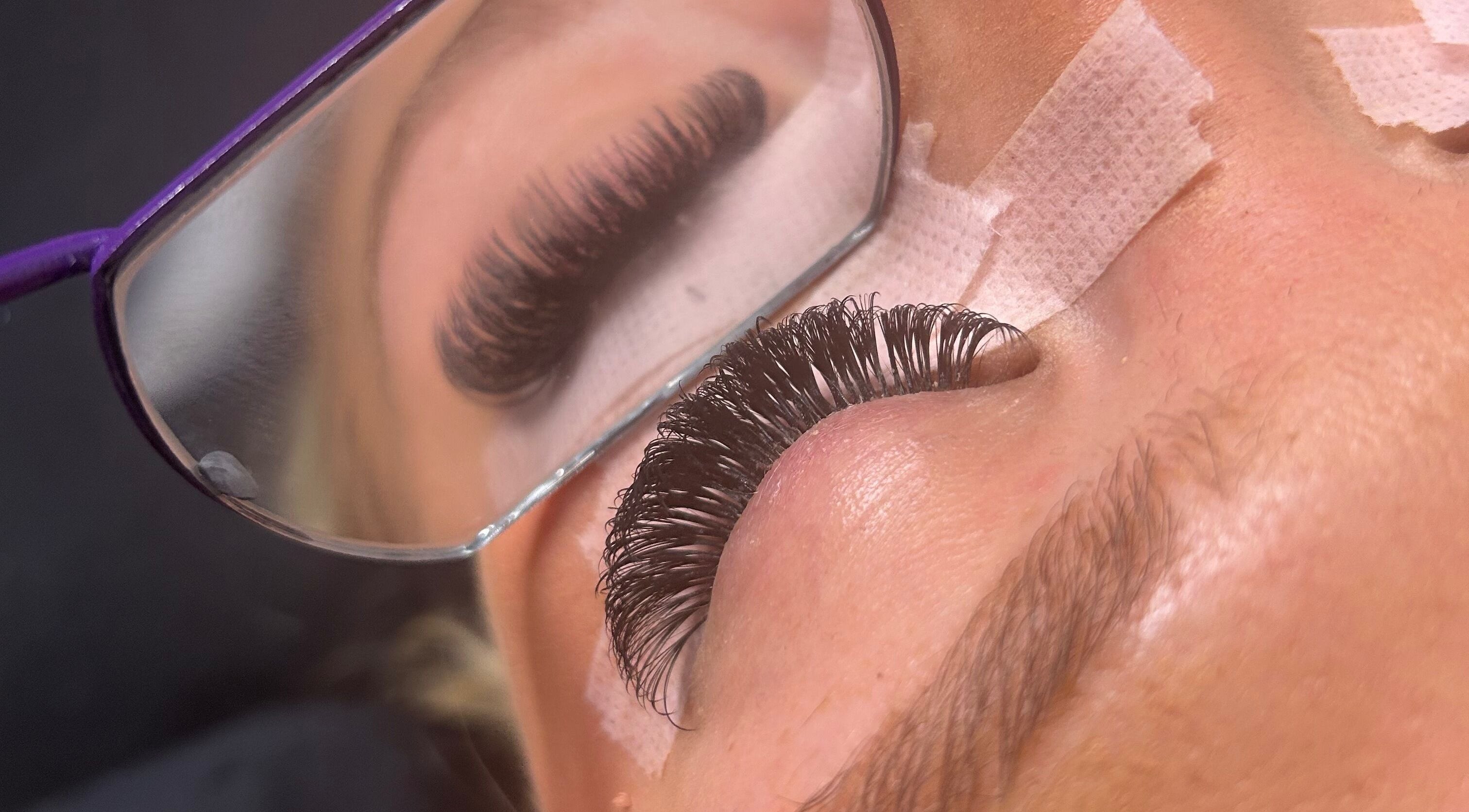 Close-up of eyelash extensions at LylaLash, Matson, England, GB, mirrored in stylist's glasses.