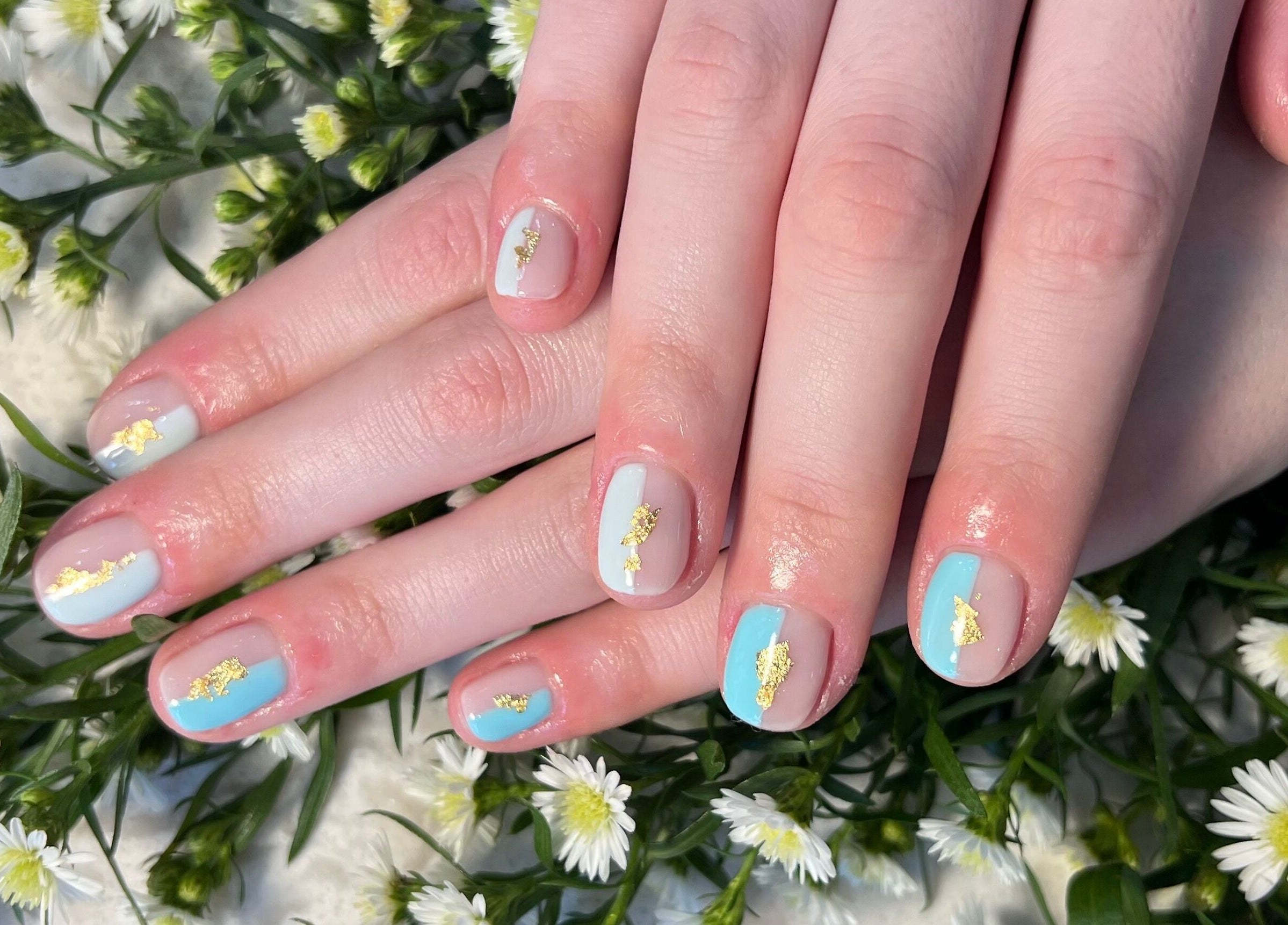 Elegant gold leaf nail art at My River Nails and Spa LLC in Great Falls, Virginia, US, surrounded by flowers.