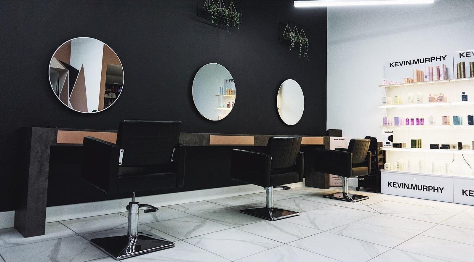 Modern salon interior at Black House Salon, Huddersfield, England, GB, featuring sleek chairs and mirrors.
